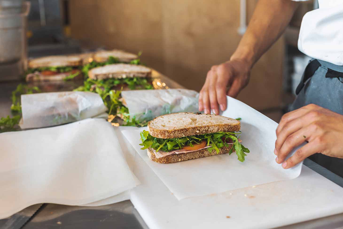 Freshly prepared sandwiches being wrapped by chef